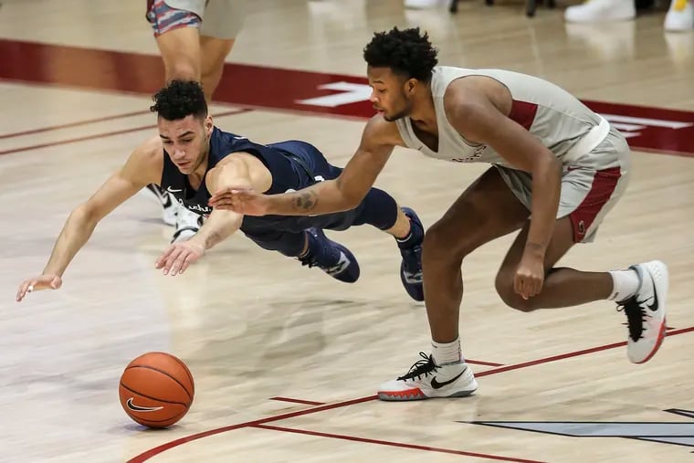 Saint Joseph's Myles Douglas and Richmond's Tyler Burton try for the loose ball during the 1st half at the Hagan Arena in Philadelphia, Tuesday,  January 26, 2021.
