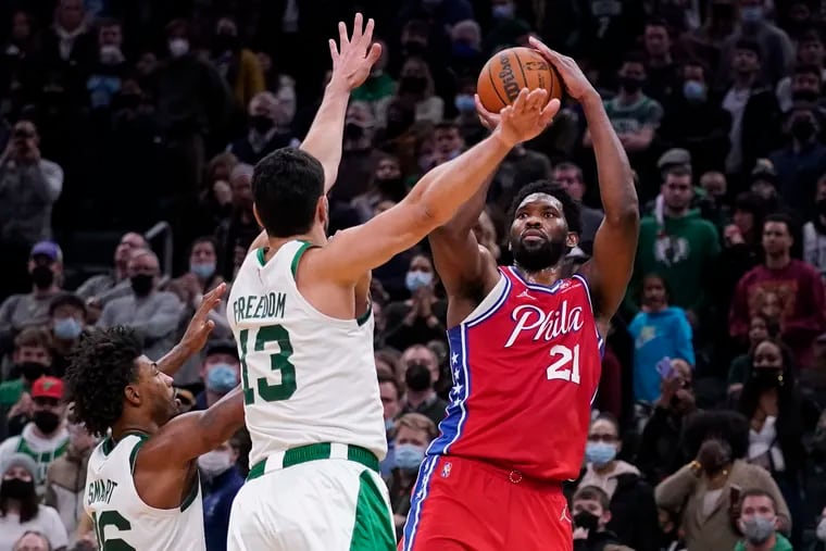 Philadelphia 76ers center Joel Embiid (21) shoots over Boston Celtics center Enes Freedom (13) and guard Marcus Smart, left, during the second half of an NBA basketball game, Monday, Dec. 20, 2021, in Boston. (AP Photo/Charles Krupa)