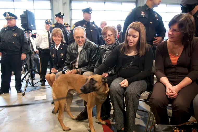 Attending the ceremonial signing of &quot;the Brad Fox Law&quot; were his widow, Lynsay, and his police dog, Nick, who was with Fox when he was slain.