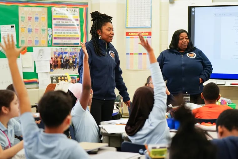 Takia McClendon (left) in her classroom at Bethune Elementary School in Philadelphia, Friday, Feb. 16, 2024. McClendon is considering leaving the teaching job she loves because of the low pay. "I’ve made more money selling bikes and sneakers."