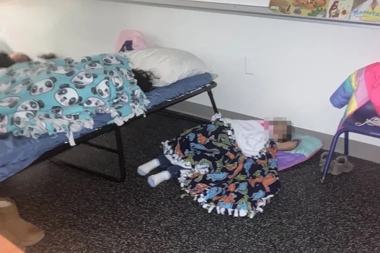 Children sleep in a conference room at the Philadelphia Department of Human Services. A DHS spokesperson said children there sleep on air mattresses or cots, never on the floor. Note: This photo has been edited to obscure faces of children.