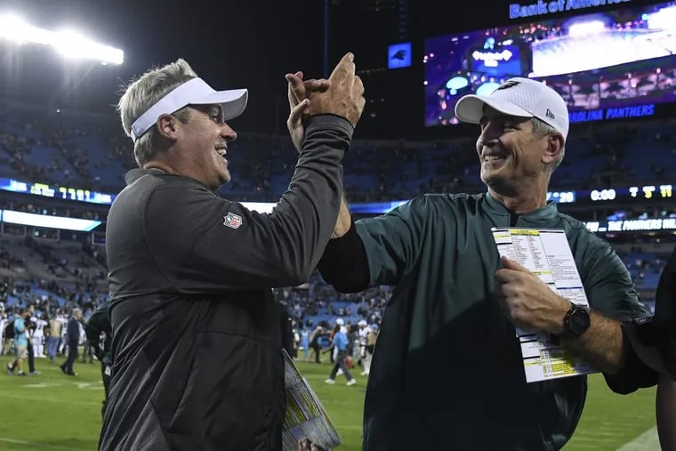 Eagles head coach Doug Pederson (left) and offensive coordinator Frank Reich celebrate the team’s win over the Panthers at Bank of America Stadium October 12, 2017. Eagles beat the Panthers 28-23. CLEM MURRAY / Staff Photographer