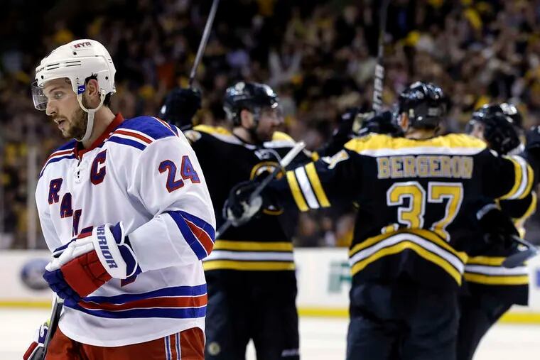 The Rangers' Ryan Callahan skates away as the Bruins celebrate a second-period goal. (ELISE AMENDOLA / Associated Press)