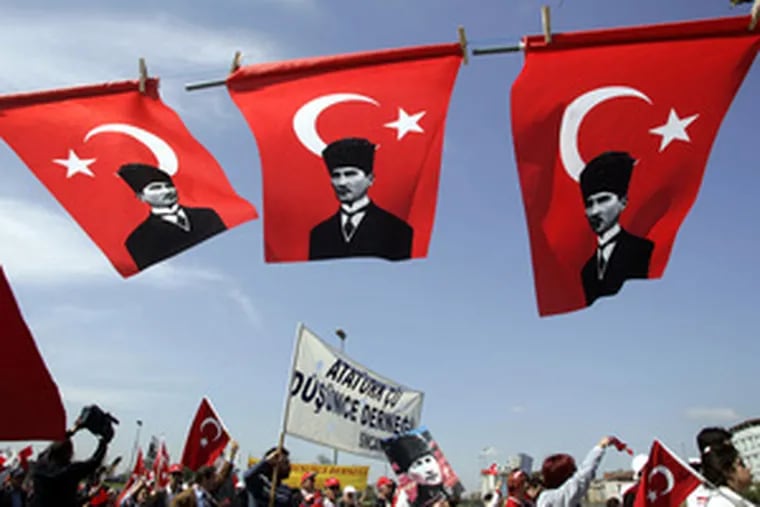 Demonstrators walk beneath Turkish flags carrying portraitsof modern Turkey&#0039;s pro-secular founder, Kemal Ataturk.