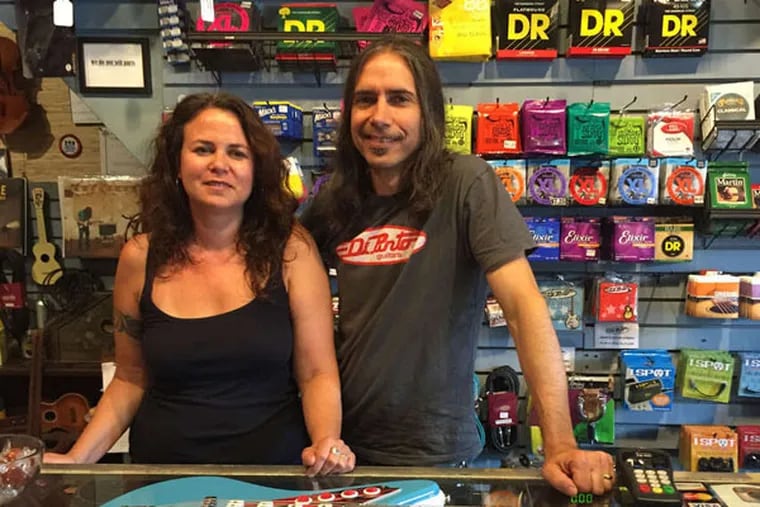 Sophy and Chris DiPinto behind the counter of their guitar shop. (Michael Hinkelman/Daily News Staff)