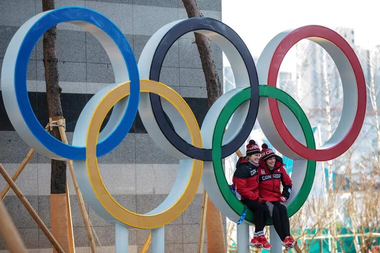 Canadian athletes pose for a photograph by the Olympic rings in the Olympic Villageon Feb. 6, 2018 in Gangneung, South Korea.
