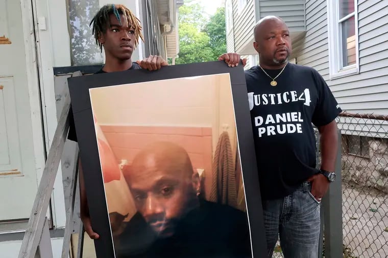 Joe Prude, right, uncle of Daniel Prude, and Daniel's nephew Armin, stand with a picture of Daniel Prude in Rochester, N.Y. in September 2020. In a decision announced Tuesday, a grand jury voted not to charge officers shown on body camera video holding Daniel Prude down naked and handcuffed on a city street last winter until he stopped breathing.