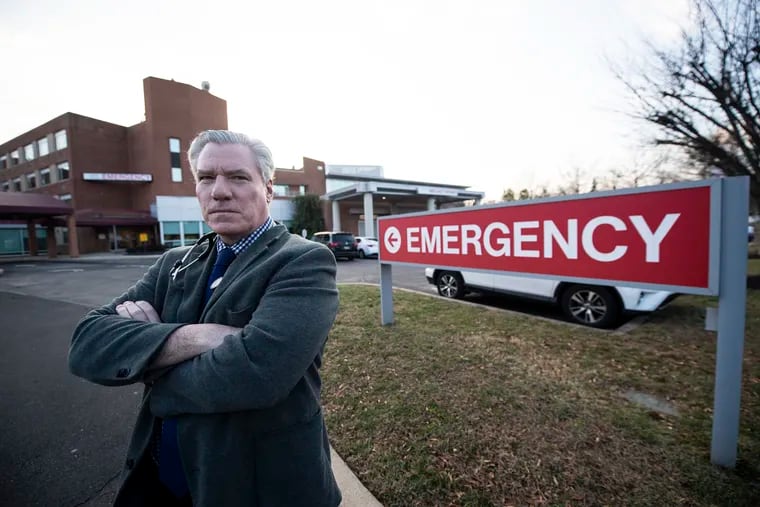 Gerald O'Malley stands in front of the emergency room of the Lower Bucks Hospital in Bristol, where he previously worked. O'Malley is one of nearly 60 doctors and physicians assistants at three suburban hospitals owned by Prime Healthcare that is out thousands of dollars in back pay after a turnover in the contractor that helps staff the ERs.