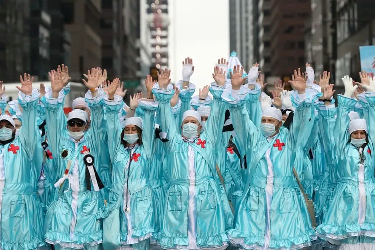 The Two Street Stompers pay homage to healthcare workers as they perform in front of City Hall at the 2022 Mummers Parade in Philadelphia on Sunday, Jan. 2, 2022. The parade was postponed a day due to the rain on New Years Day in 2022.