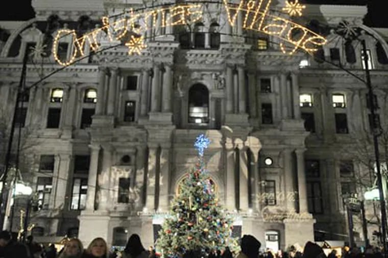 Philadelphia's Christmas tree sits below the "Christmas Village" sign - with the word 'Christmas' restored - after removal of the word Monday caused a public outcry. Mayor Nutter led a tree lighting ceremony Thursday evening. (Sarah J. Glover / Staff Photographer)