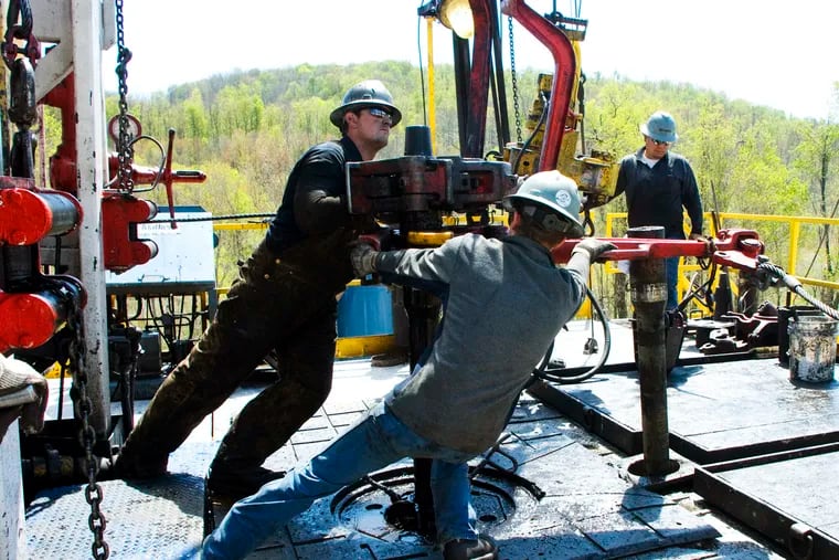 Workers move a section of well casing into place at a Chesapeake Energy natural gas well site near Burlington, Pa., in Bradford County in 2010.