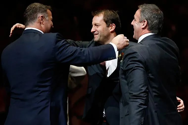 Former Flyer Mikael Renberg hugs linemates Eric Lindros and John LeClair during the Flyers Hall of Fame Induction ceremony. (Yong Kim/Staff Photographer)