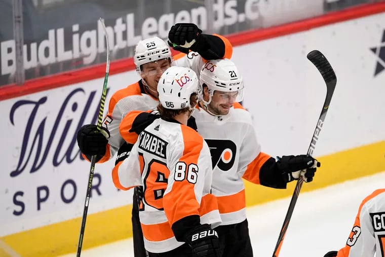 Flyers center Scott Laughton (21) celebrates his second goal of the game with wingers Joel Farabee (86) and James van Riemsdyk (25) during the second period.