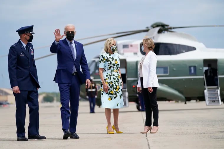 President Joe Biden waves as he and first lady Jill Biden walk to board Air Force One for a trip to Georgia to mark his 100th day in office.