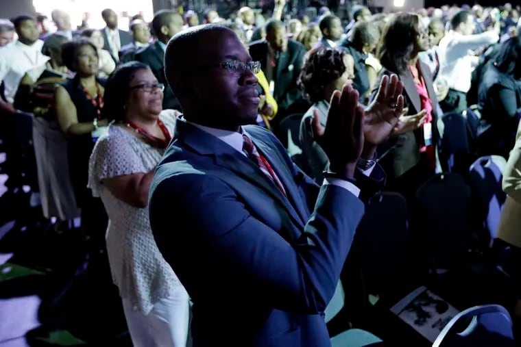 PHOTOS: ASSOCIATED PRESS Jeff Anoka , of Hanover, Md., applauds Attorney General Eric Holder yesterday at the end of his remarks at the Pennsylvania Convention Center in Philadelphia.