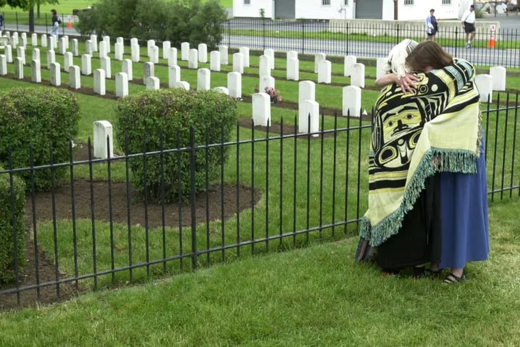 Alaska anthropologist Eleanor Hadden ( left) and  Cumberland County historian Barb Landis embrace following a ceremony at the Indian Cemetery at the the Army War College in Carlisle, Pa.  There are 14 native Alaskans buried in the cemetery including Hadden's great aunt, Mary Kininnook.