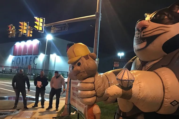 From left: Howard Van Burean, Tony Iannucci and James Keegan of Sheet Metal Workers Local 19, with their mascot Fat Cat, were among union picketers leafletting workers and visitors to the new Holtec plant in Camden, N.J. before dawn on Thursday, Sept. 27. The power plant parts company's Pennsylvania plant is unionized, but union leaders say Holtec bosses have refused to negotiate union training or representation, despite up to $260 million in labor-backed state and local tax breaks. Holtec owner Krishna Singh has cited  the poor quality of city labor as an obstacle to recruiting. But the union has more than 80 members who are Camden residents, and can train many more, says assistant business agent Bryan Bush