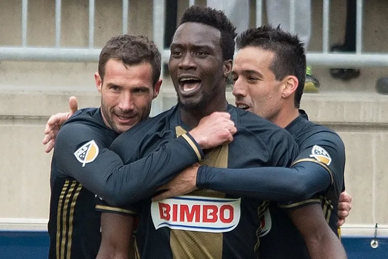 The Union's C.J. Sapong (center) is congratulated by teammates Chris
Pontius (left) and Ilshinho after scoring the first of two goals against the New England Revolution.