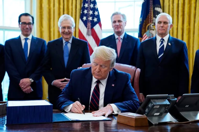 On March 27, President Donald Trump signed the coronavirus stimulus relief package at the White House in Washington, as from left, Treasury Secretary Steven Mnuchin, Senate Majority Leader Mitch McConnell of Ky., House Minority Kevin McCarthy of Calif., and Vice President Mike Pence, looked on.