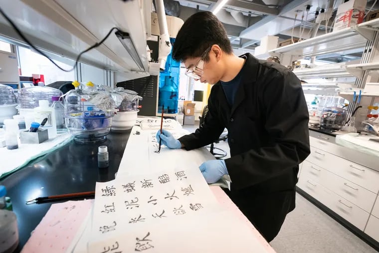 Teng Zhang, a Drexel Ph.D. student in materials science and engineering, writes with ink that he made from high-tech materials called MXenes.