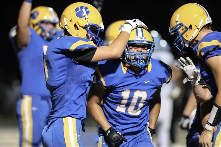 Downingtown East’s  Garvey Jonassaint (10) celebrates with his teammates after scoring a touchdown in a 61-44 victory over North Penn last month.