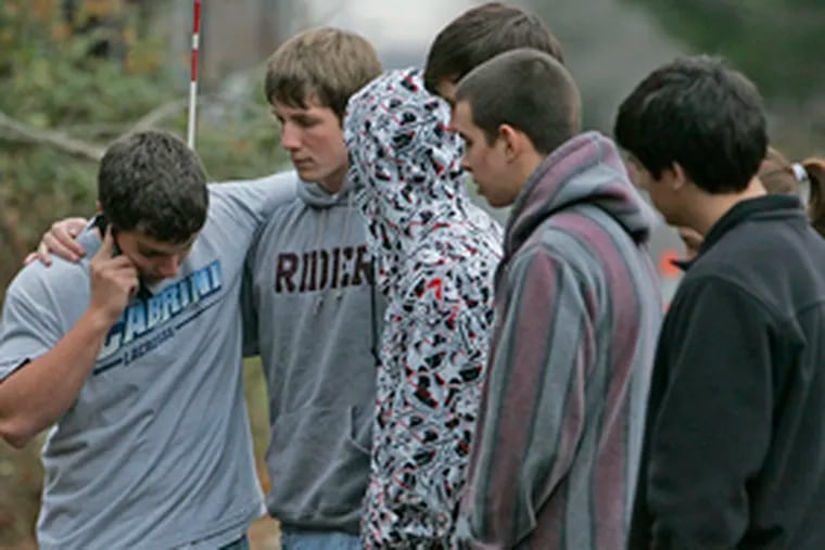 Moorestown High students comfort one another at the crash site. Grief counselors were on hand for faculty and students.