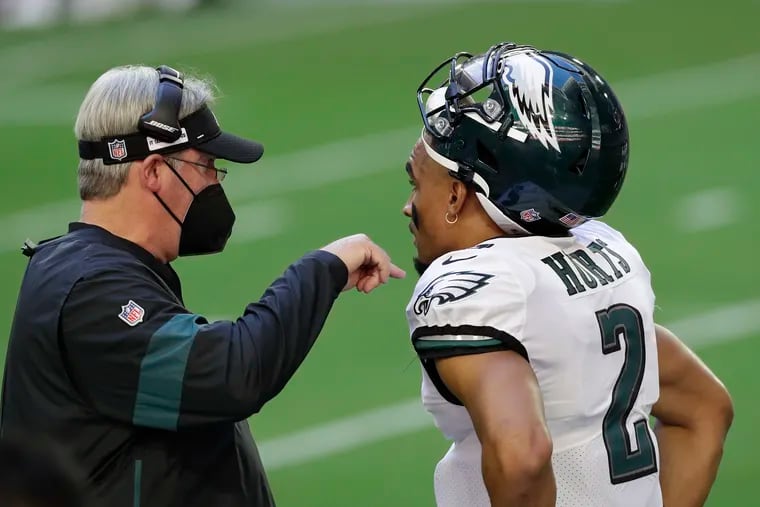 Eagles quarterback Jalen Hurts listens to head coach Doug Pederson after Hurts committed an intentional grounding penalty in the first quarter of Sunday's 33-26 loss to the Arizona Cardinials.