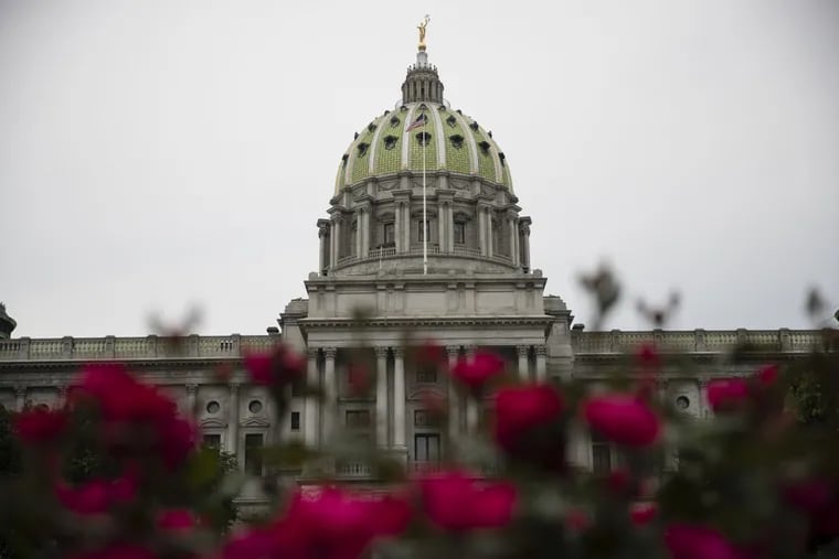 Shown is the Pennsylvania Capitol building along with roses in Harrisburg, Pa. A Democratic electoral wave in the Philadelphia suburbs turned at least 12 state House and four state Senate districts from red to blue. Five House and two Senate districts, all but one most recently in Republican hands, remain too close to call.