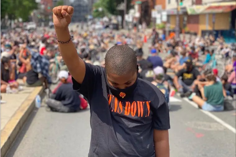 Jahmill Meadows, 12, lifts his fist while marching at the June 6 protest for Black Lives Matter. Meadows is one of 10 members of the Young Flames, a youth rap group from South Philadelphia that advocates for empowerment, positivity, and anti-gun violence.