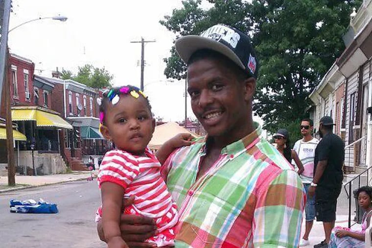 In a 2009 family photo, Joshua Raheem holds his daughter Zhydia. Serving a life sentence after he was convicted of murder in 2015, Raheem is seeking a new trial.