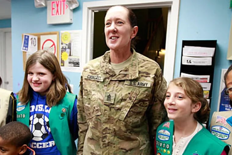 Army Staff Sgt. Polly Crandall poses with two Girl Scouts who were involved with writing letters and cards to troops. (David Swanson/Staff Photographer)