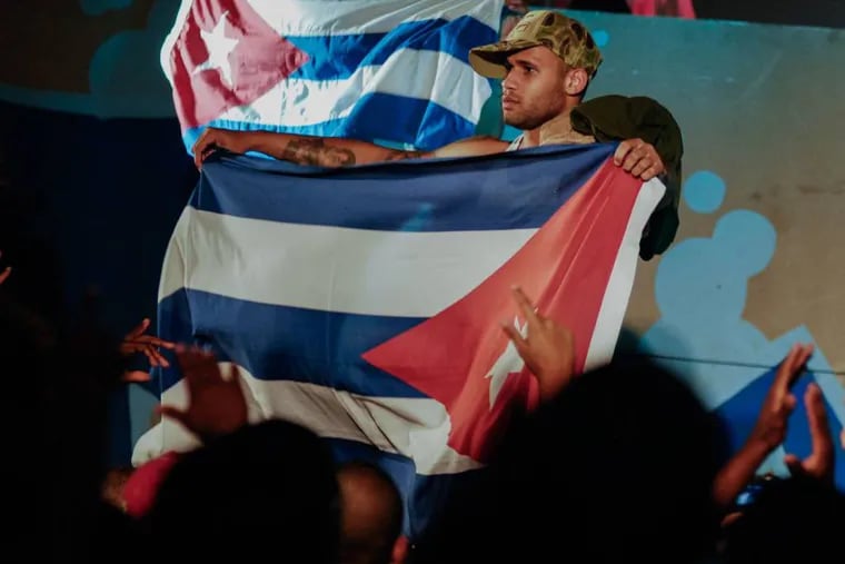 In this April 23, 2010, photo, Cuban singer Bian Rodriguez, member of the Los Aldeanos, holds a Cuban flag as they play in concert at the Acapulco Theatre in Havana, Cuba. (AP Photo)