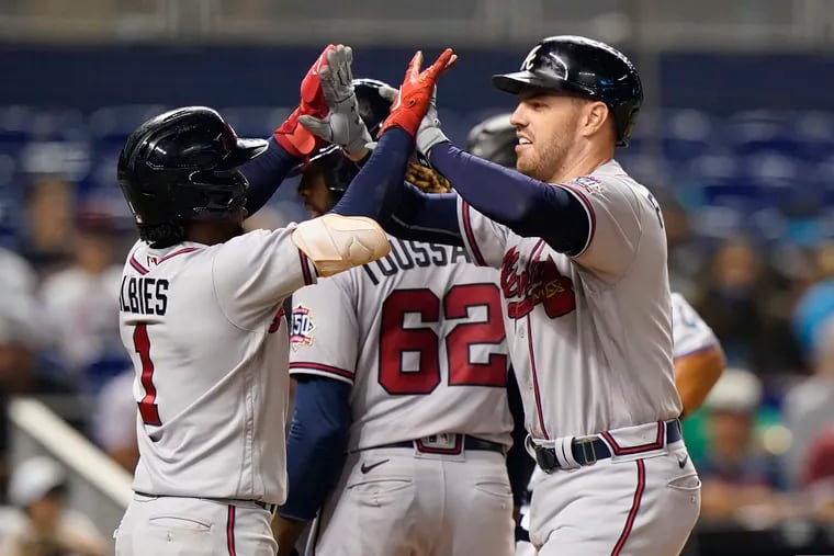 The Atlanta Braves' Freddie Freeman celebrates with Ozzie Albies (1) and Touki Toussaint (62) after hitting a home run that scored them all during the fourth inning against the Miami Marlins on Monday.