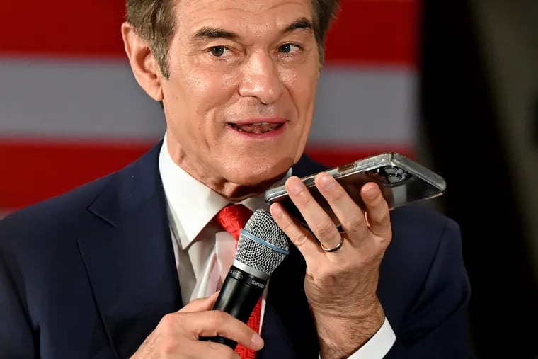 Pennsylvania Republican Senate candidate Mehmet Oz holds his phone to the microphone, sharing a live call from former President Donald Trump with his audience at a May 16 town hall in Blue Bell.