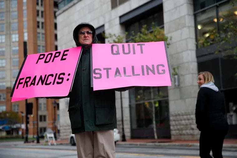 Robert Hoatson, of West Orange, N.J., holds protest signs outside of a hotel hosting the United States Conference of Catholic Bishops' annual fall meeting, Tuesday, Nov. 13, 2018, in Baltimore. (AP Photo/Patrick Semansky)