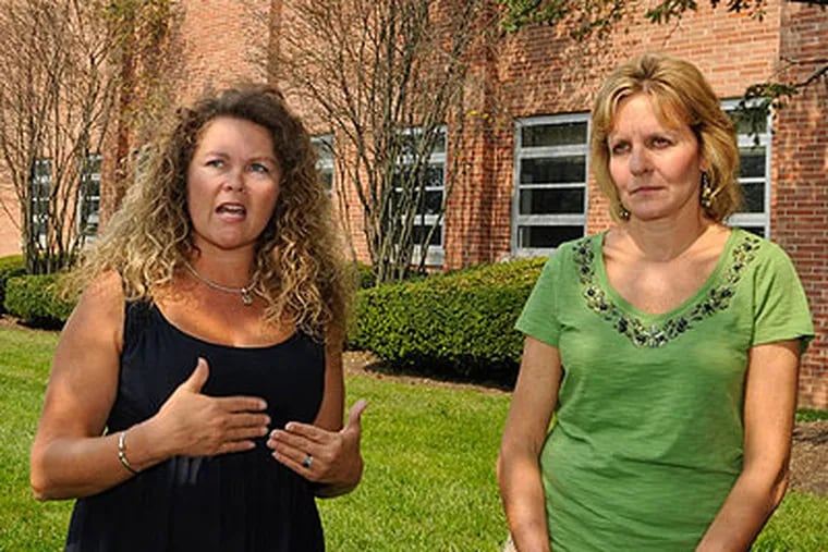 Theresa Keel (left) and Diane Babb, co-founders of Catholic Parents Respond, hold a press conference outside Lansdale Catholic High to urge parents not to pay tuition until both sides sit down with a mediator. (Ron Tarver / Staff Photographer)