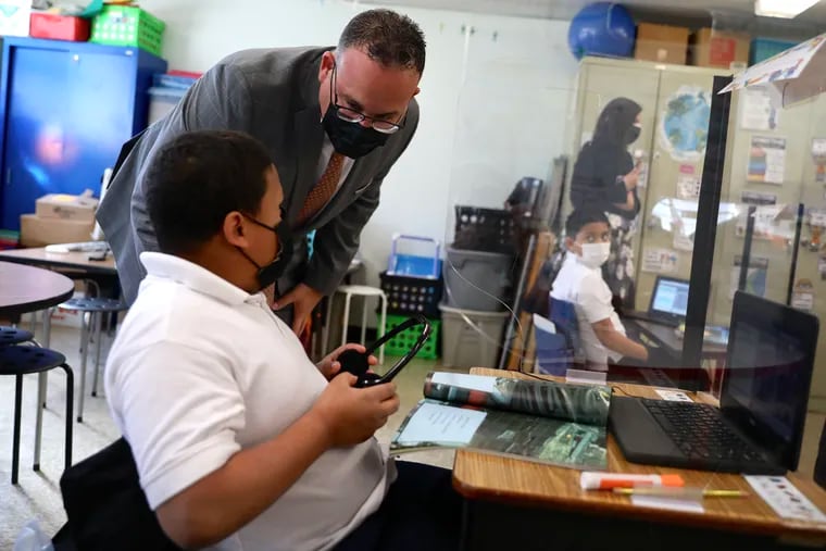 U.S. Secretary of Education Miguel Cardona talks with a second-grade student during a visit to the Olney Elementary School Annex in North Philadelphia on Tuesday, April 6, 2021.