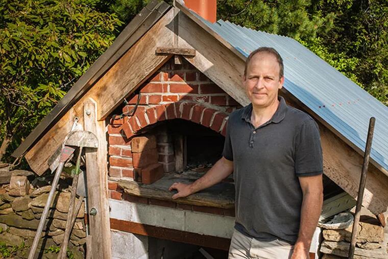 Sam Finney uses the brick pizza oven in his backyard about every other week to make pizza, bread, roasted meats, and even granola. It takes up to three hours to prepare the fire and preheat the bricks. ( Matthew Hall / Staff Photographer )