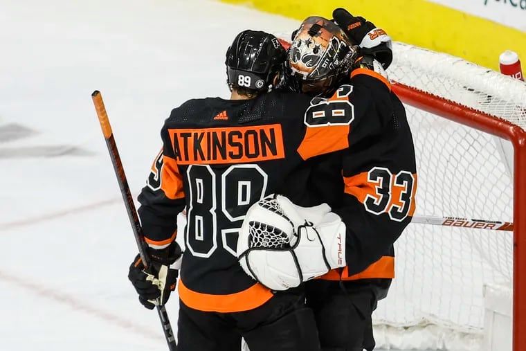 Flyers goaltender Samuel Ersson celebrates with his teammate right winger Cam Atkinson after beating the Coyotes 5-3 at the Wells Fargo Center.