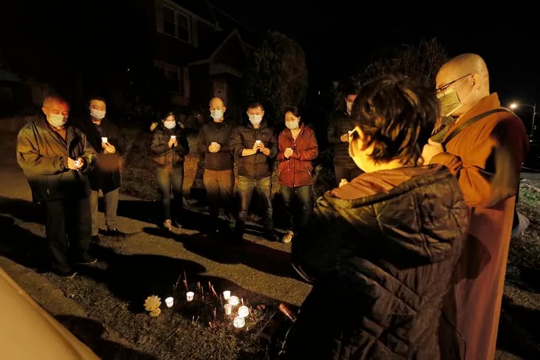 Family and friends pray during the vigil for Saixiang Lin at St. Vincent Street and Summerdale Ave. in Phila. on Nov. 14, 2020. Saixiang Lin was one of five fatal hit-and-run victims in Philly over the last week.
