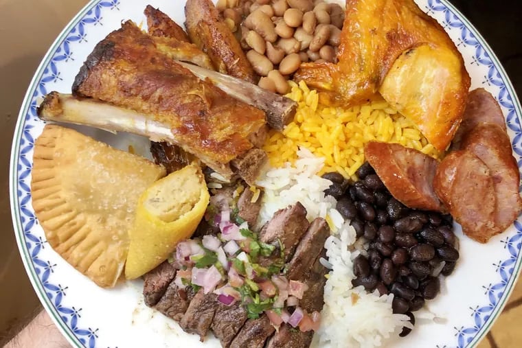 Craig LaBan's is laden with a feast of Colombian flavors from On Charcoal in Northeast Philadelphia. Included, clockwise from the top, stewed red beans, chicken and rice, Colombian sausage, black beans, churrasco skirt steak, empanadas, pork ribs and sweet plantains.