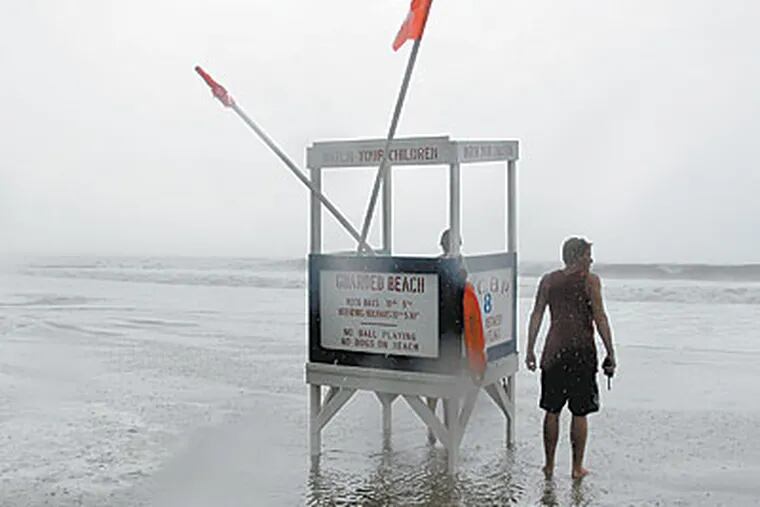 Ocean City lifeguards keep watch as high surf kicked up by Hurricane Bil lpushes pass his lifeguard stand. (Ron Tarver / Staff Photographer)