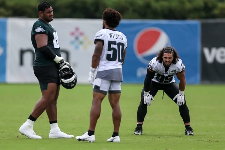 Eagles offensive tackle Jordan Mailata (68),  linebacker Eric Wilson (50) and linebacker Joe Ostman talked on the field after training camp at the NovaCare Complex on Tuesday.