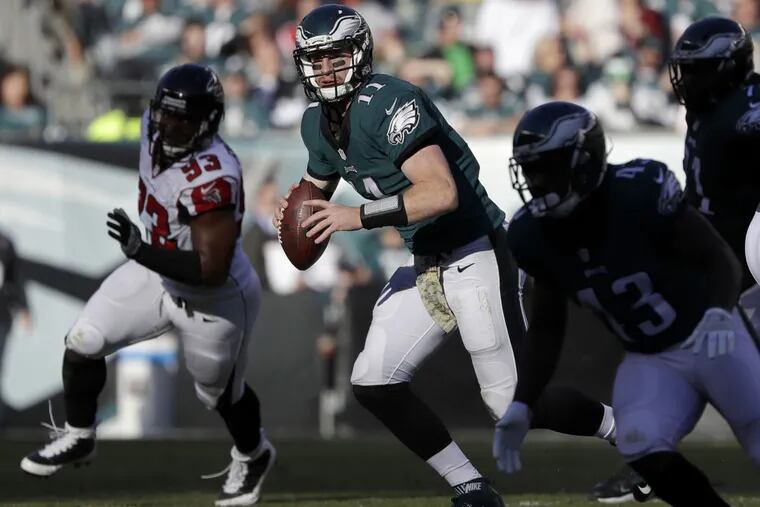 Eagles quarterback Carson Wentz scrambles ahead of Falcons defensive end Dwight Freeney during the second quarter on Sunday, Nov. 13, 2016 in Philadelphia.