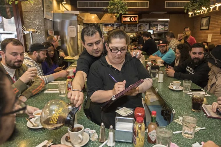 Pablo Asiain (left), who has been working at Little Pete’s for 14 years, fills up a customers cup of coffee on the last day of business. Waitress Elizabeth Milano  has been a waitress for the Koutroubas family for 22 years
