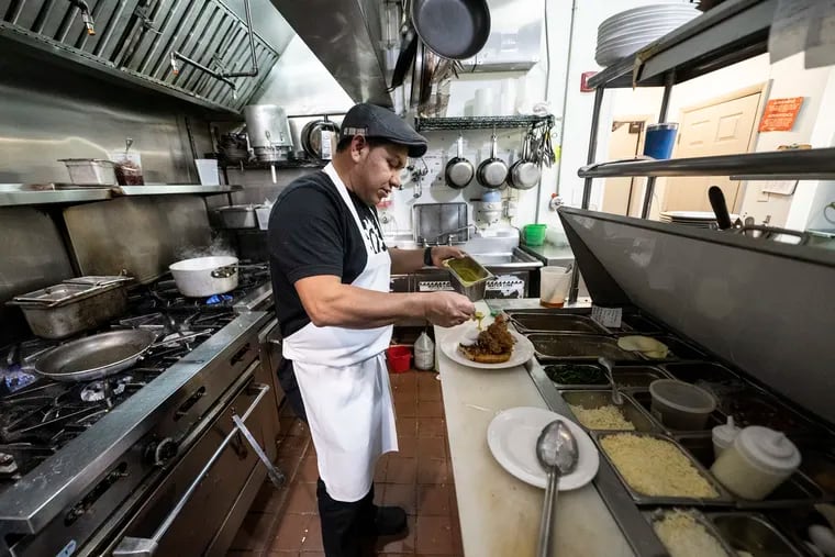 Head chef and co-owner Juan Lopez cooks an egg dish at his restaurant On Point Bistro in Philadelphia. The restaurant has had to raise prices to cover the increasing cost of ingredients.