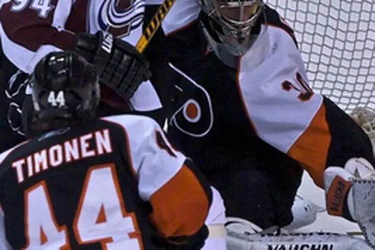 Flyers defenseman Ossi Vaananen and goalie Antero Niittymaki prevent Colorado&#0039;s Ryan Smyth from scoring, while Kimmo Timonen joins fray in front of net.
