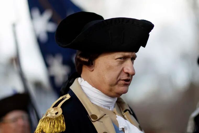 PHOTOS: MEL EVANS / STAFF PHOTOGRAPHER Gen. George Washington , played by John Godzieba, readies himself to cross the Delaware River yesterday, in the 62nd annual re-enactment of the boat trip that turned the tide of the Revolutionary War.