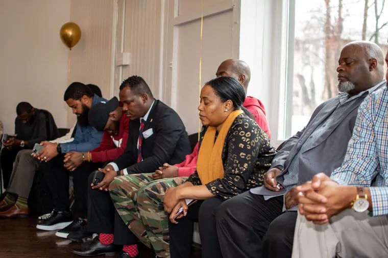 Black Men Heal clients, providers, and supporters close their eyes in a therapeutic technique at a fundraiser held at Our House Culture Center in Germantown on Jan. 11, 2020.