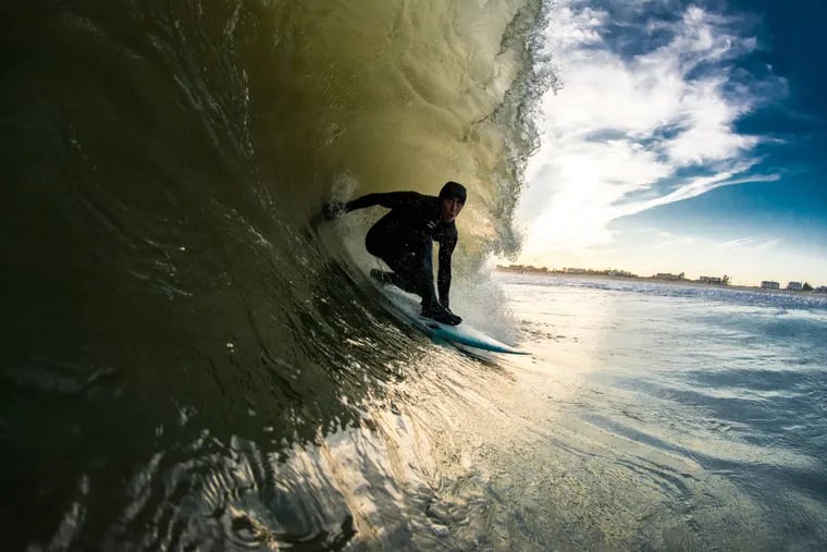 Rob Kelly surfs down the shore in the winter
